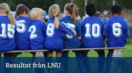 Barn i fotbollströjor med nummer på ryggarna sitter bredvid varandra på en bänk.