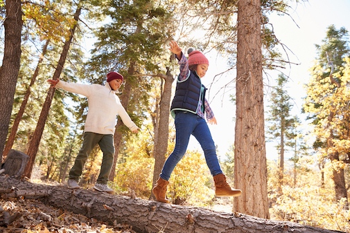 Two siblings playing i the woods