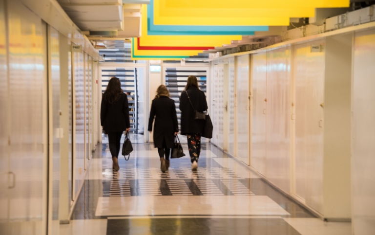 Tre personer går i korridoren i Södra huset Frescati, Stockholms universitet