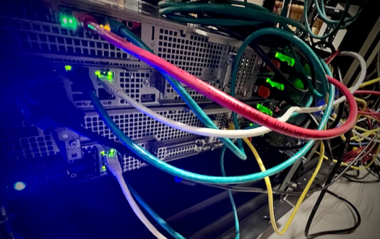 The back of a server with cables in different colors and flashing lights
